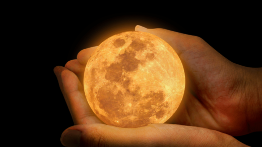 pair of hands holding a small glowing full moon