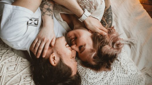 couple laying in bed together laughing and cuddling